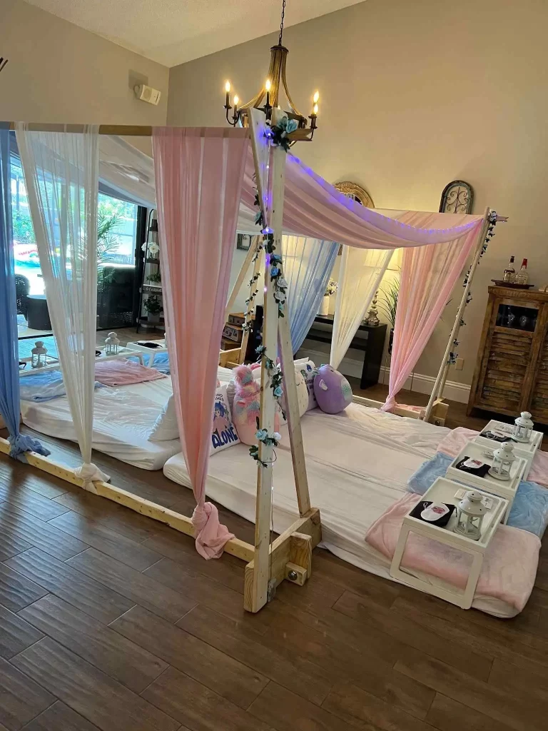 A pink and blue canopy bed set up in a living room for a Texas party rental.