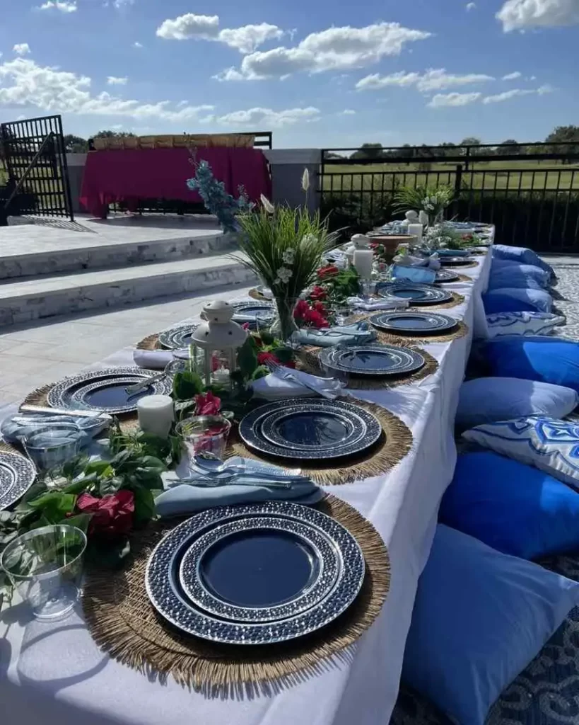 A table set with blue and white plates and pillows, available for party rental in Texas.