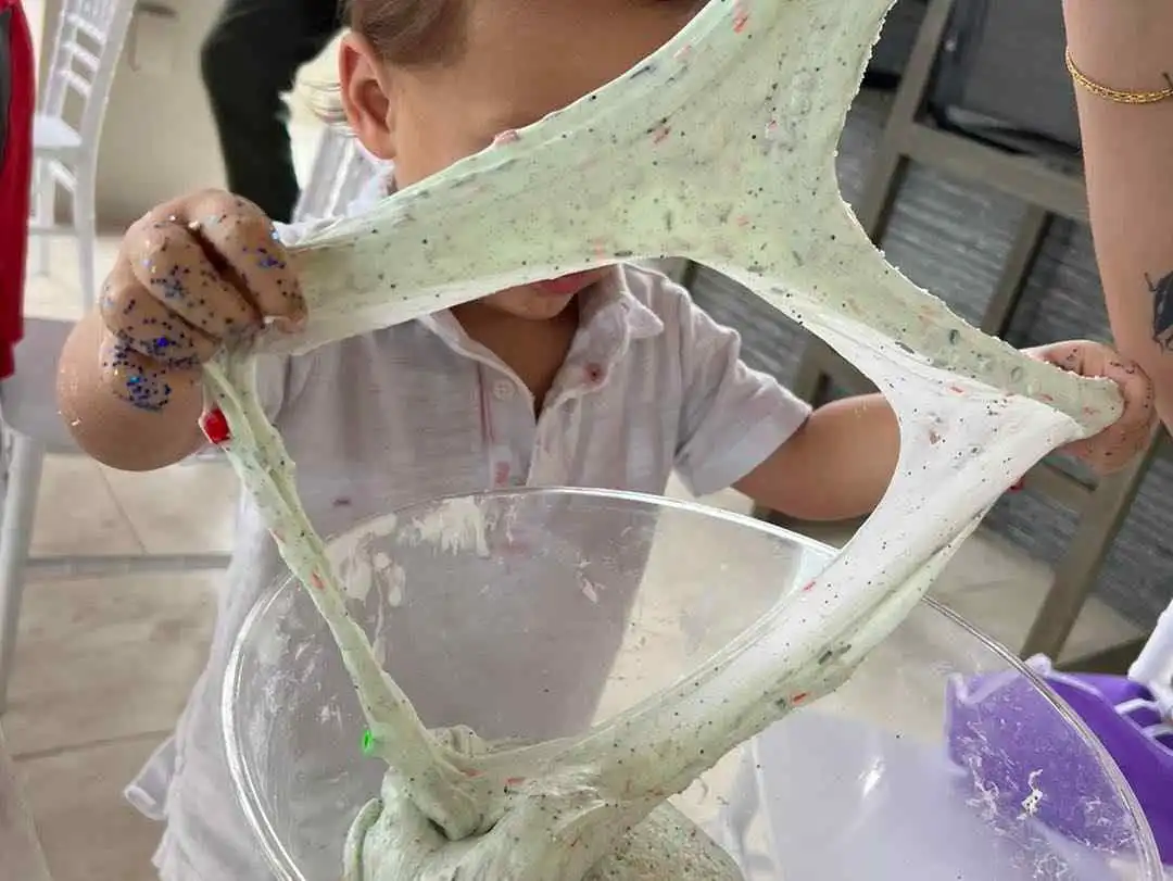 A child is playing with a bowl of sand at a build-a-buddy party.