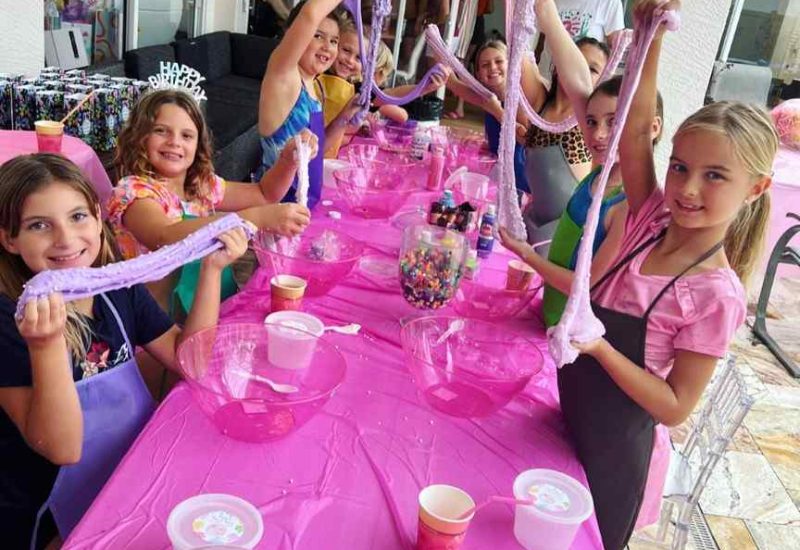 A group of girls at a Texas-themed party rental with pink tables and balloons.